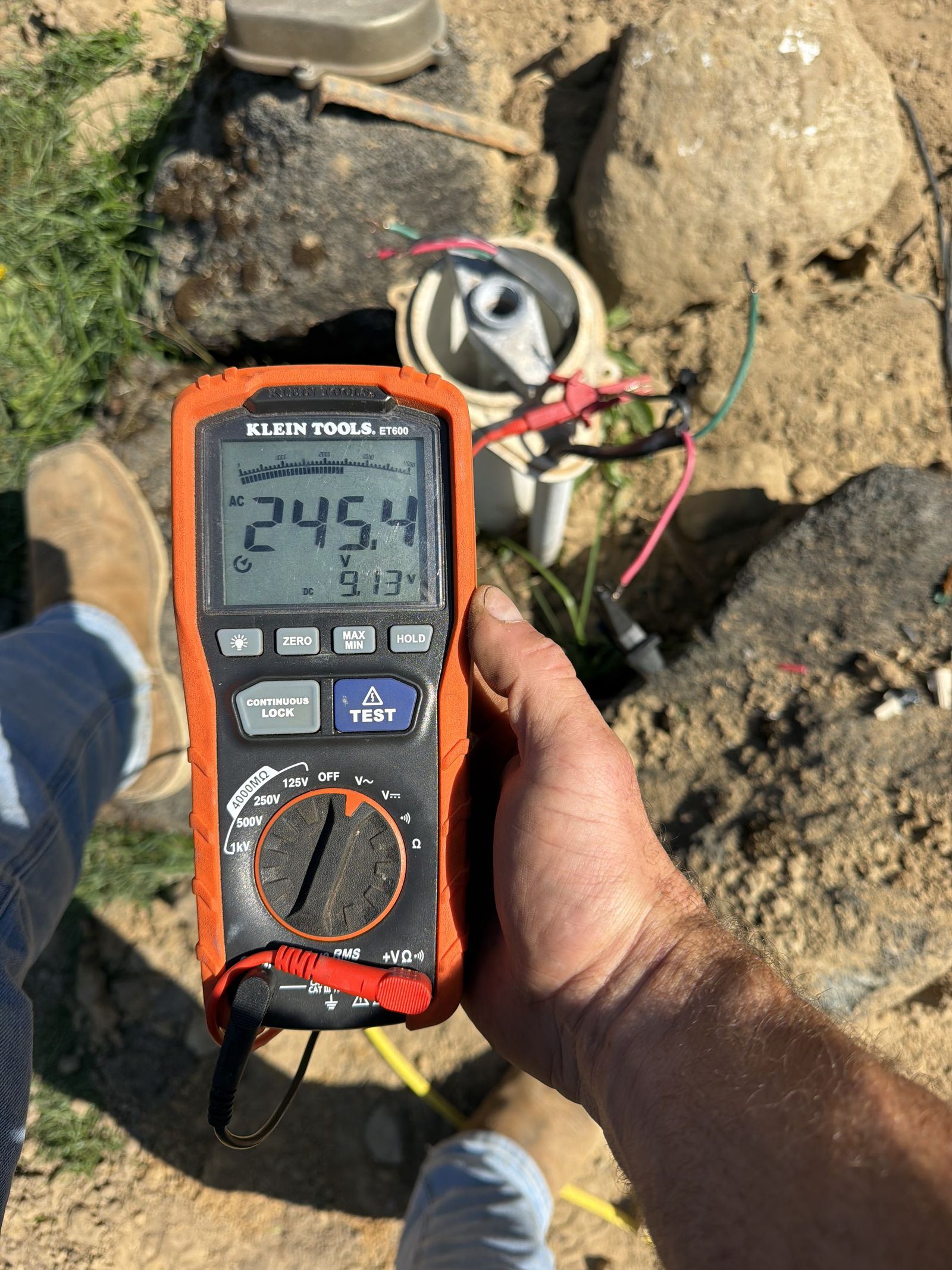 Testing voltage at the wellhead with a multimeter during well pump troubleshooting in Oakland County, MI